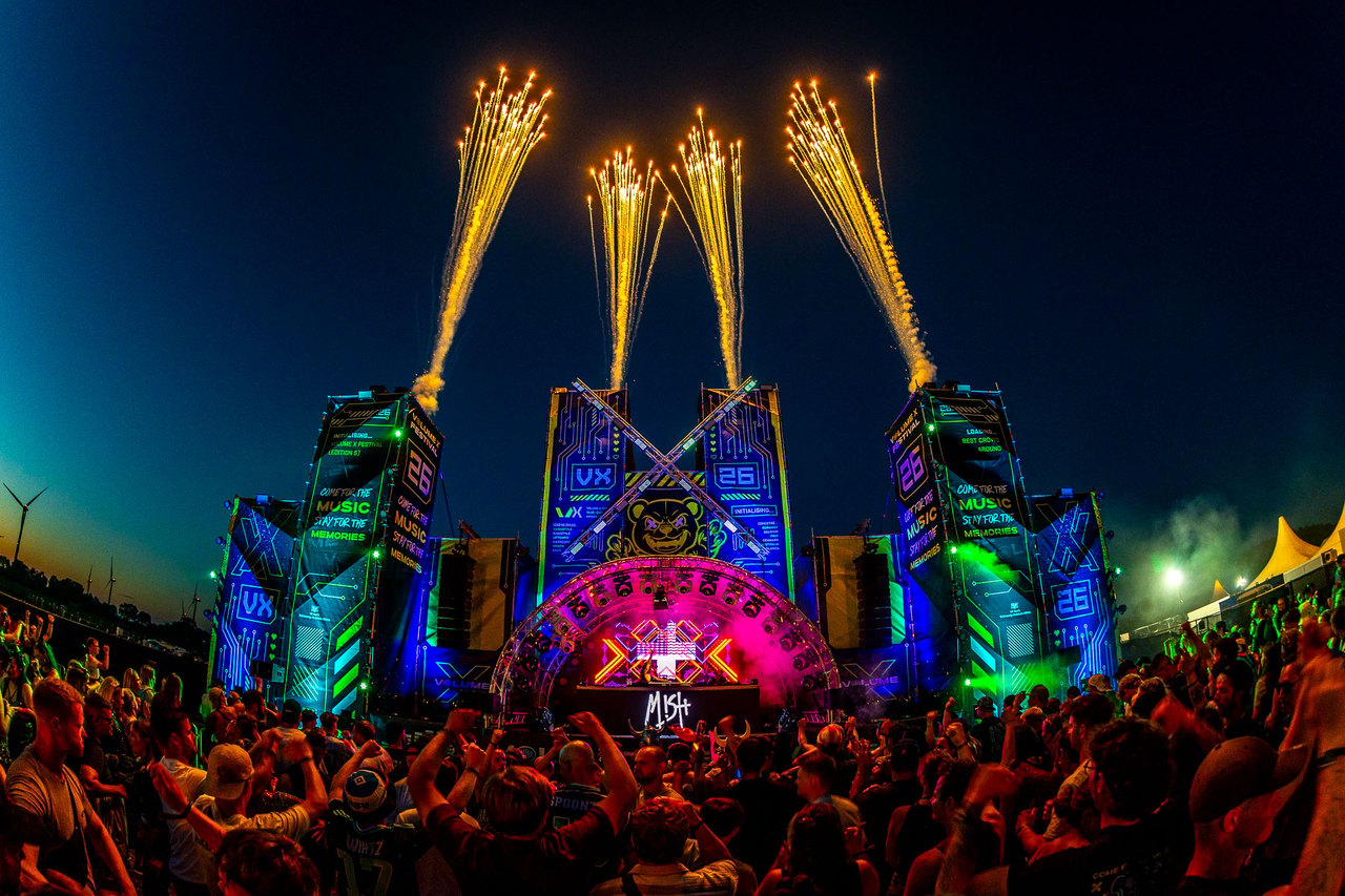 Die XVille Stage bei Nacht: monumentales Bühnendesign mit Pyroshow und Lichteffekten vor der Menge.